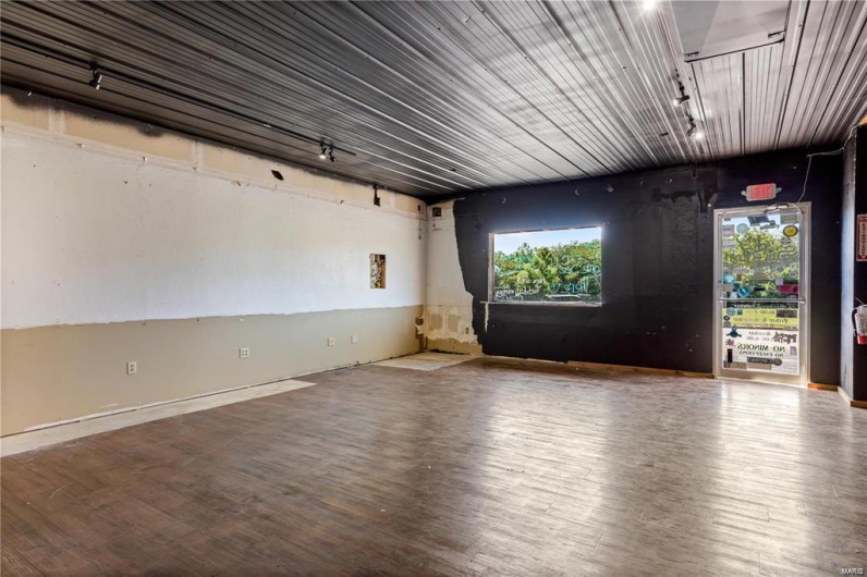 Empty room featuring wood-type flooring and rail lighting