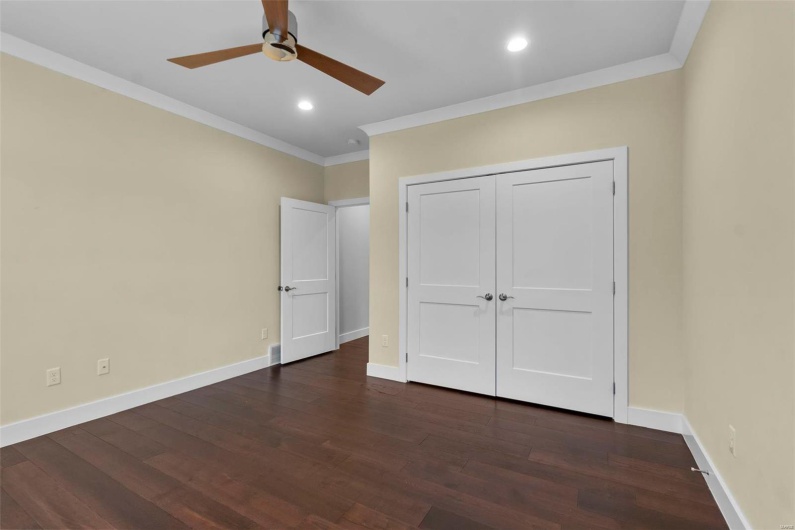 Unfurnished bedroom with a closet, ceiling fan, dark hardwood / wood-style flooring, and ornamental molding