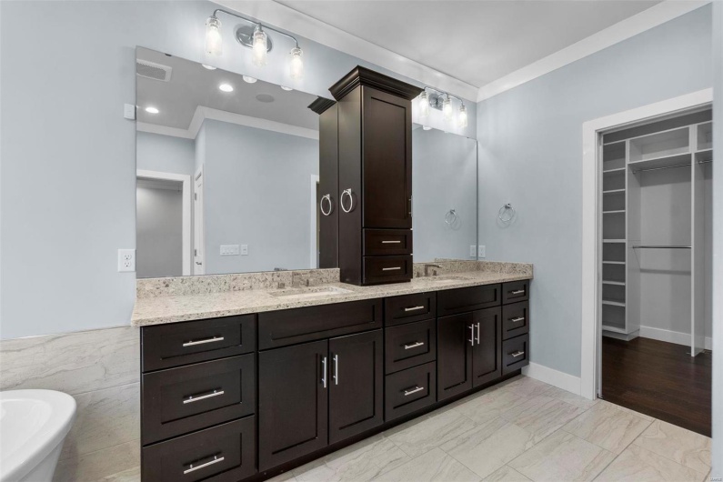 Bathroom with vanity, a bathtub, crown molding, and tile walls