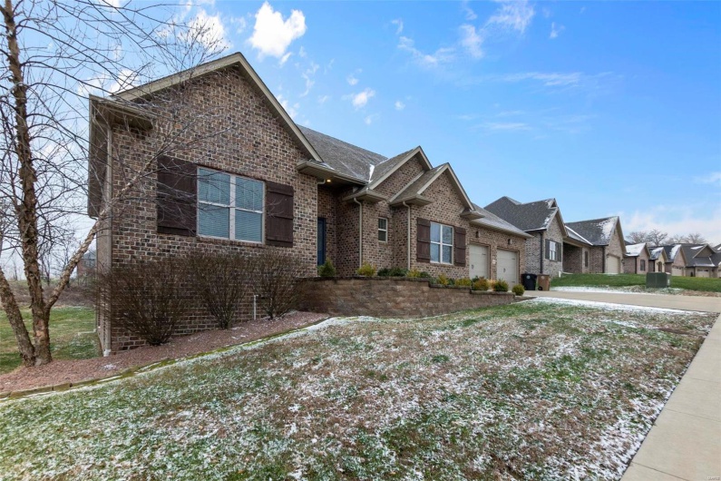View of front of property with a garage and a front lawn