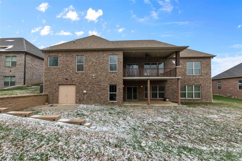 Snow covered rear of property with a balcony, ceiling fan, and a patio area