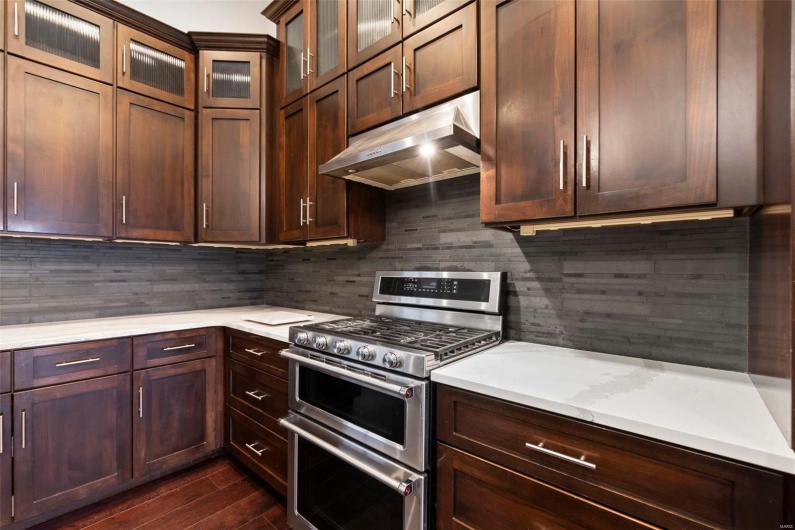 Kitchen featuring tasteful backsplash, dark hardwood / wood-style flooring, and double oven range