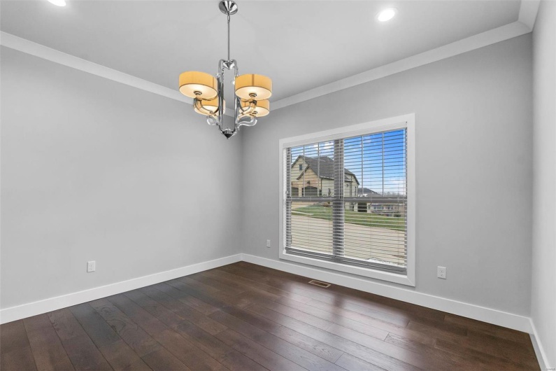 Unfurnished room with a chandelier, dark hardwood / wood-style floors, and ornamental molding
