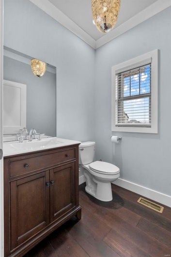 Bathroom with crown molding, toilet, vanity, and hardwood / wood-style flooring