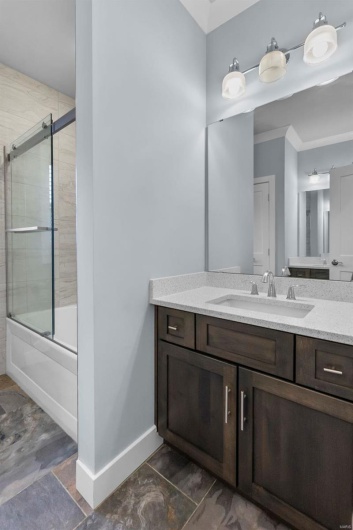 Bathroom with combined bath / shower with glass door and vanity