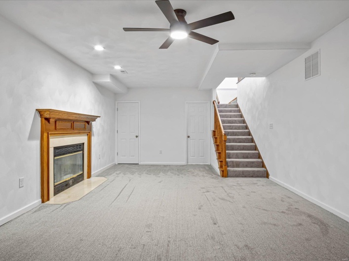 Unfurnished living room featuring light carpet and ceiling fan