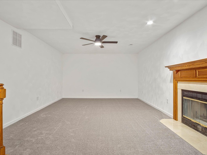 Unfurnished living room featuring ceiling fan and carpet