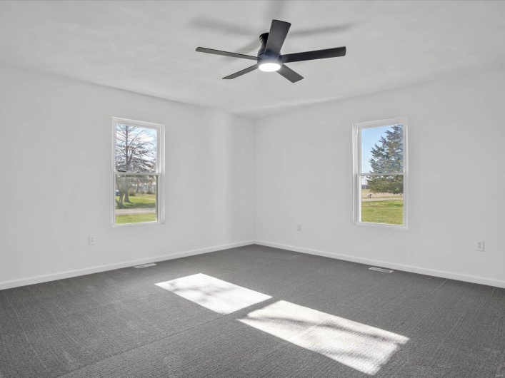 Carpeted empty room with ceiling fan