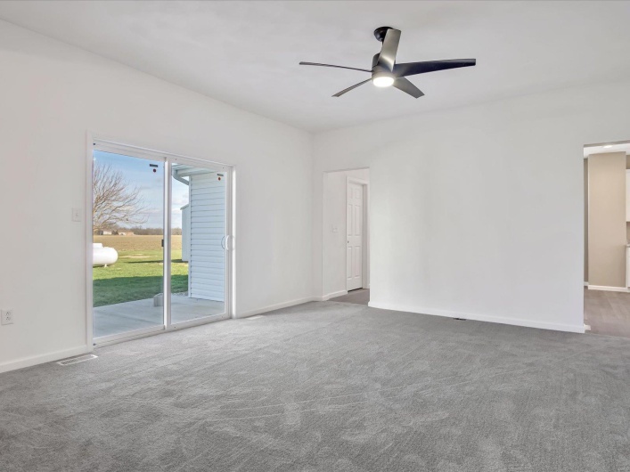 Unfurnished room with ceiling fan and dark carpet
