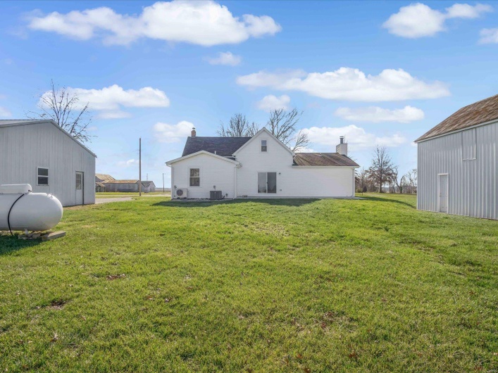 Rear view of house with a yard and central air condition unit