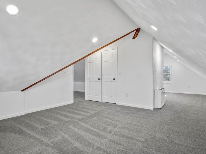Additional living space featuring carpet and lofted ceiling
