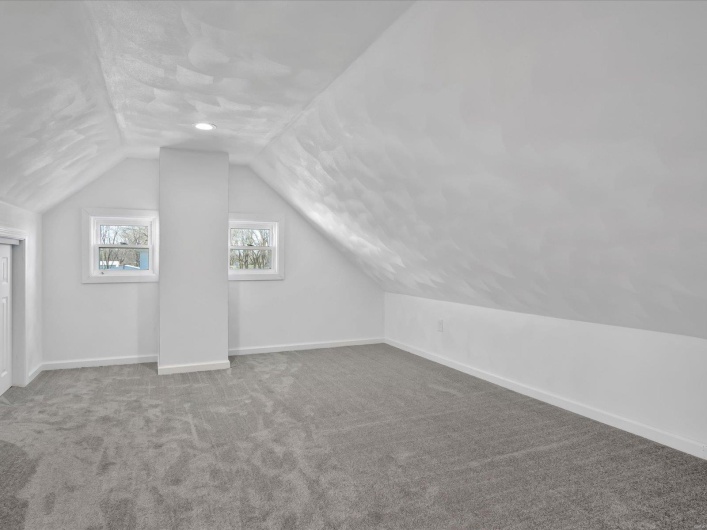 Bonus room with carpet and vaulted ceiling