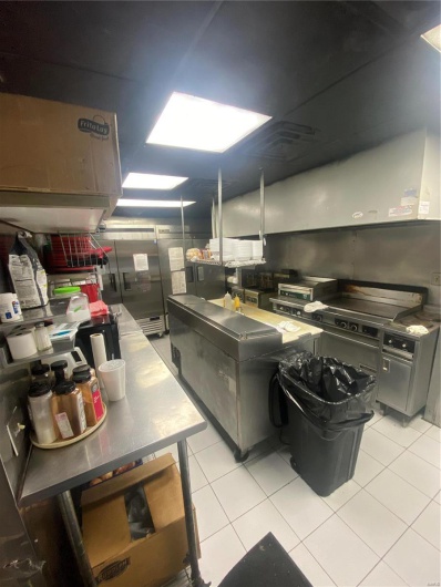 Kitchen with light tile patterned floors and fridge