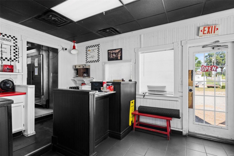 Kitchen featuring wooden walls, white cabinets, and dark tile patterned flooring