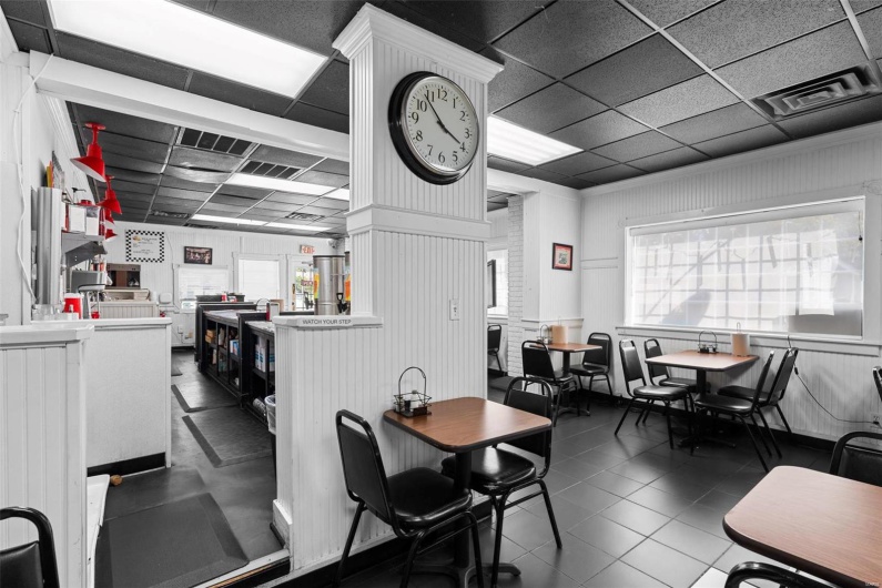 Tiled dining space with a paneled ceiling and wood walls