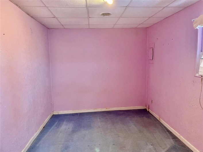 Spare room with a drop ceiling and concrete flooring