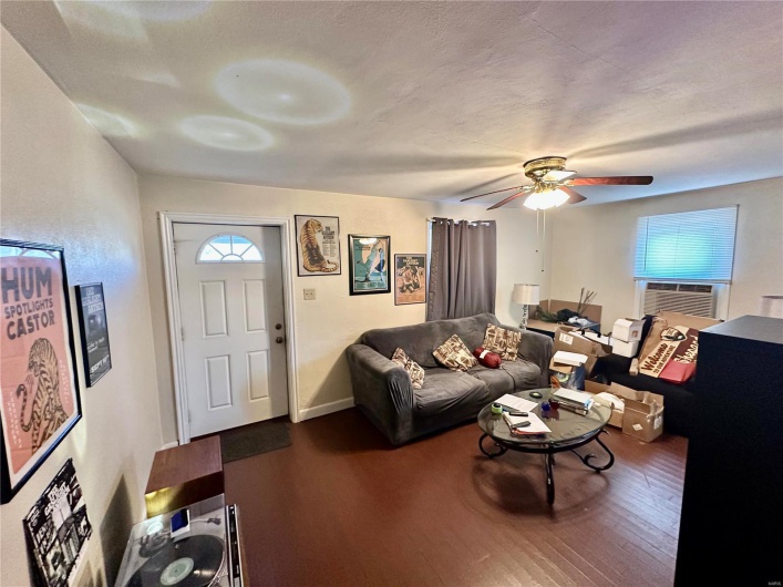Living room featuring a textured ceiling, hardwood / wood-style flooring, cooling unit, and ceiling fan