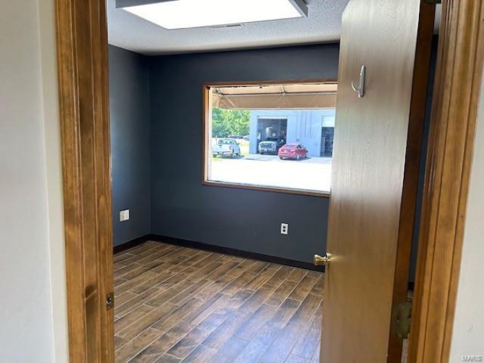 Unfurnished room with dark wood-type flooring