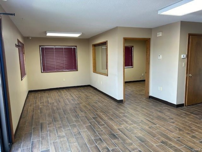 Empty room with dark hardwood / wood-style flooring