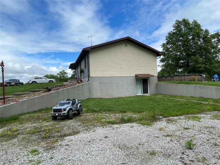 View of home's exterior with brick siding and a lawn