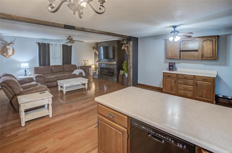 Kitchen with a textured ceiling, light hardwood / wood-style flooring, and dishwasher