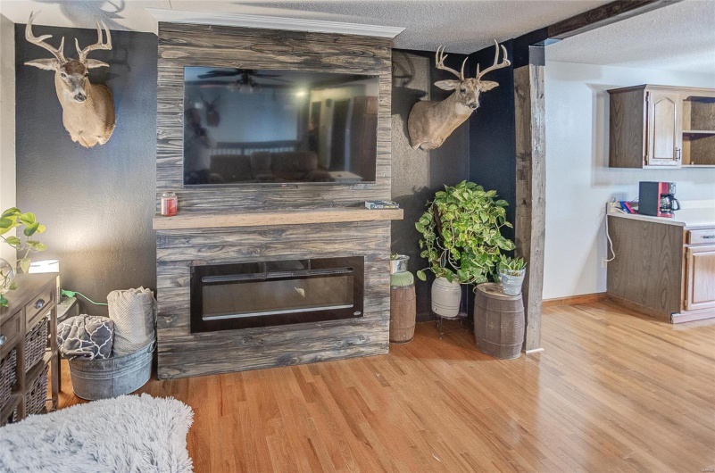 Living room with a fireplace, a textured ceiling, and light wood-type flooring