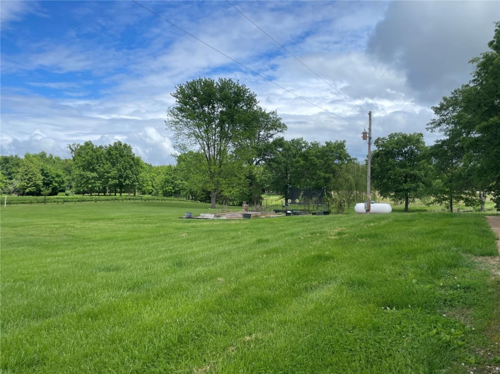 View of grassy yard with a trampoline
