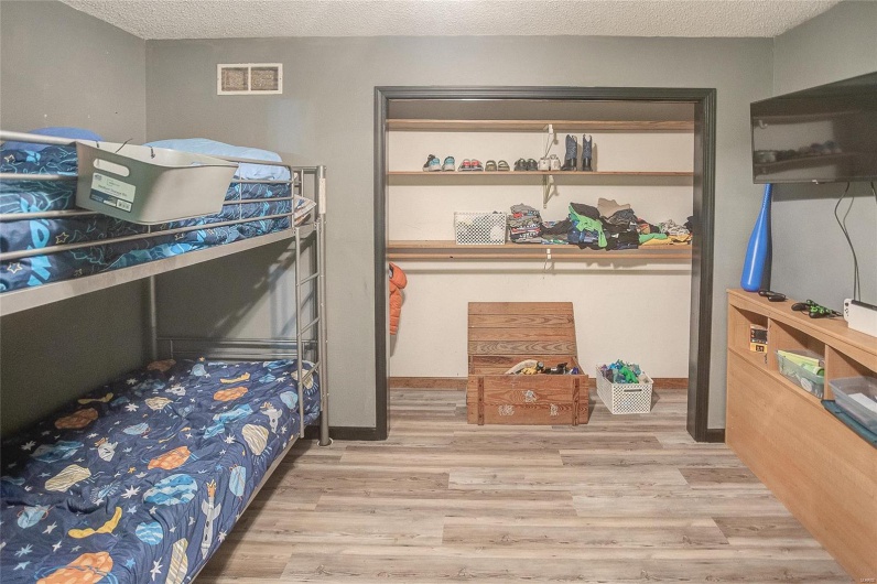 Bedroom with light hardwood / wood-style floors and a textured ceiling