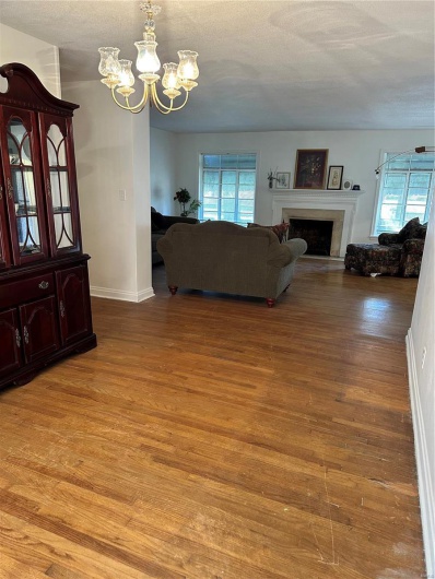 Living room with a notable chandelier and light hardwood / wood-style flooring