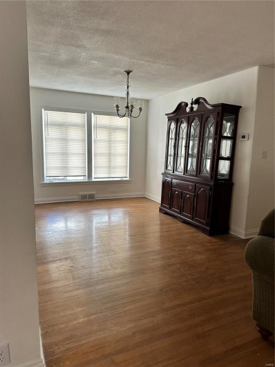 Unfurnished dining area featuring an inviting chandelier and hardwood / wood-style floors
