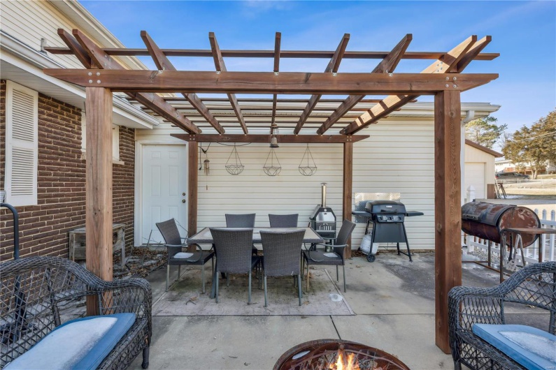 View of patio featuring an outdoor fire pit, area for grilling, and a pergola. Perfect for entertaining.