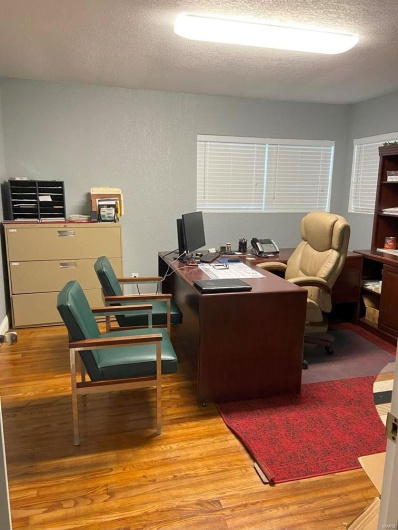 Office space with a textured ceiling and light hardwood / wood-style flooring