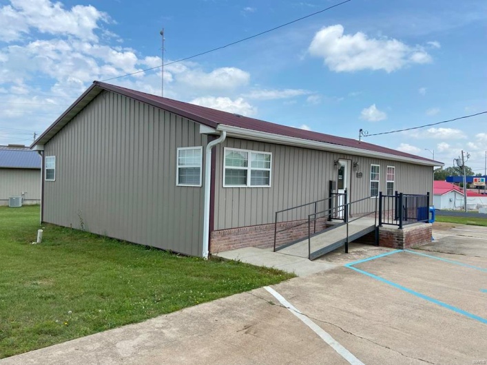 View of front of property featuring central AC unit and a front lawn