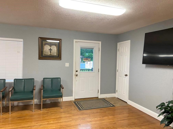 Foyer entrance with a textured ceiling and hardwood / wood-style floors