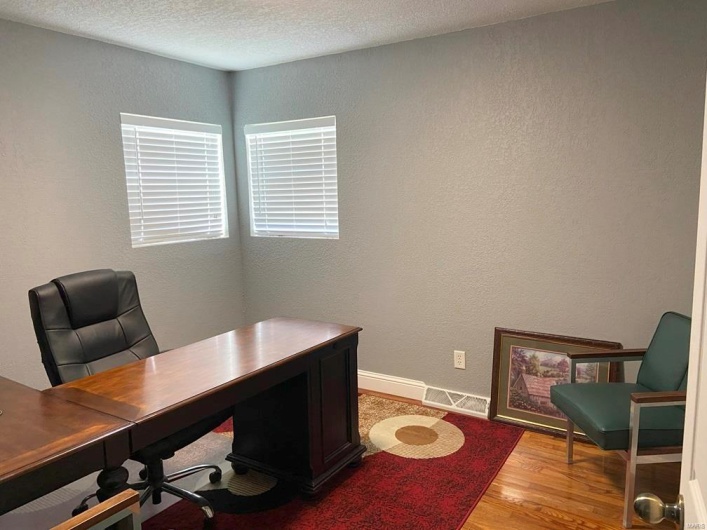 Home office featuring a textured ceiling and light wood-type flooring