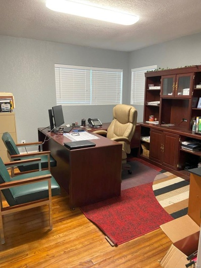 Office space with light wood-type flooring and a textured ceiling