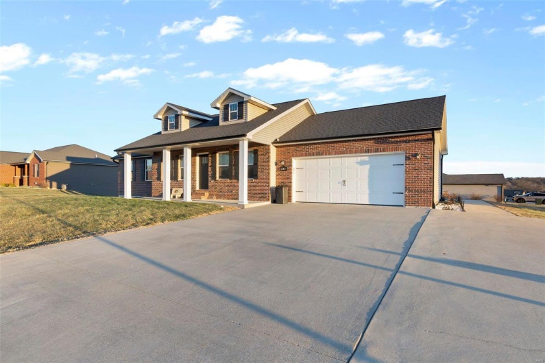 View of front of home featuring a garage, a front lawn, and a porch