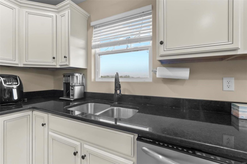 Kitchen with white cabinetry, sink, and dishwasher