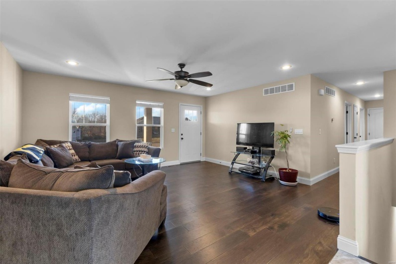 Living room featuring dark wood-type flooring and ceiling fan