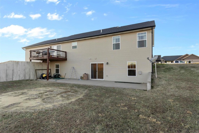 Back of property with a wooden deck, a yard, and a patio