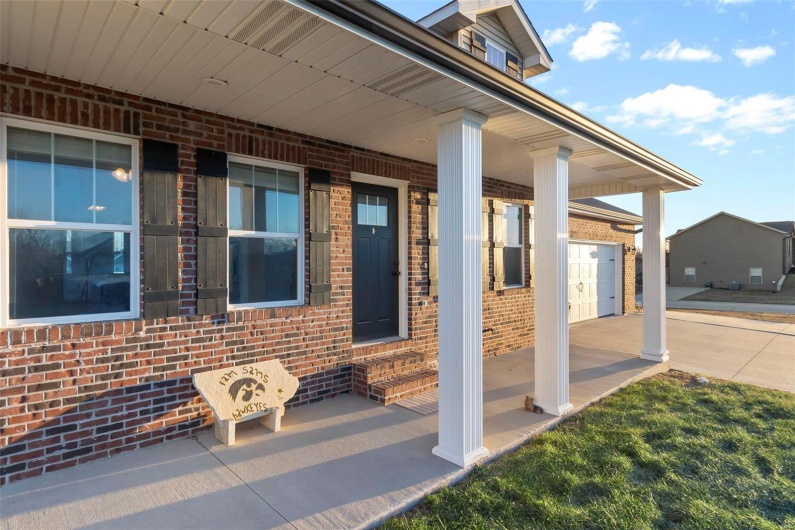 View of patio featuring a garage and a porch