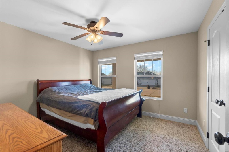Carpeted bedroom featuring ceiling fan