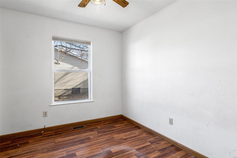 Spare room with dark hardwood / wood-style flooring and ceiling fan