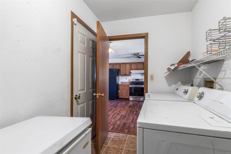 Clothes washing area featuring ceiling fan, separate washer and dryer, a textured ceiling, and dark tile patterned floors