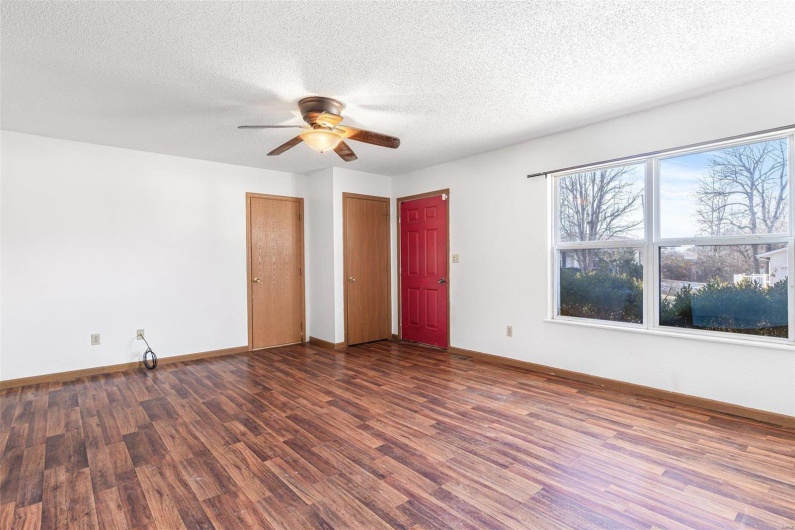 Unfurnished room with ceiling fan, dark wood-type flooring, and a textured ceiling