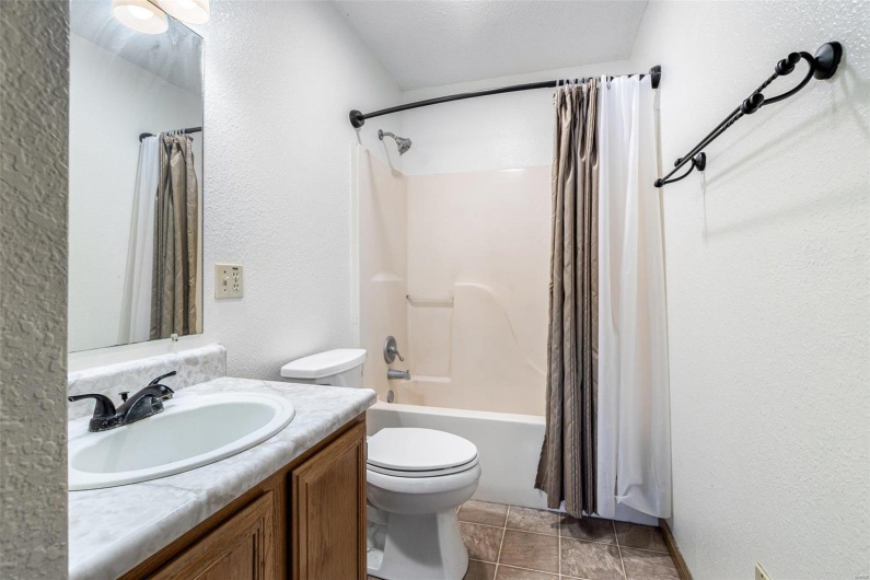 Full bathroom featuring vanity, shower / bath combination with curtain, and toilet