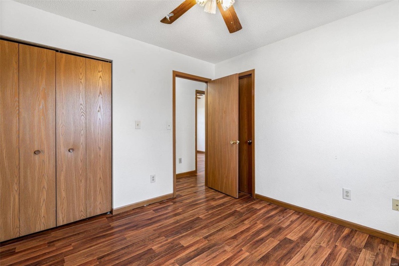Unfurnished bedroom with ceiling fan, dark hardwood / wood-style floors, and a closet