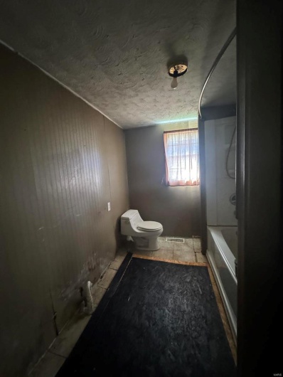 Bathroom with toilet and a textured ceiling