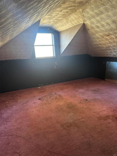 Additional living space featuring lofted ceiling, carpet, and a textured ceiling