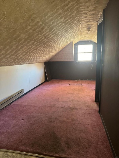 Bonus room featuring vaulted ceiling, carpet, a textured ceiling, and a baseboard heating unit